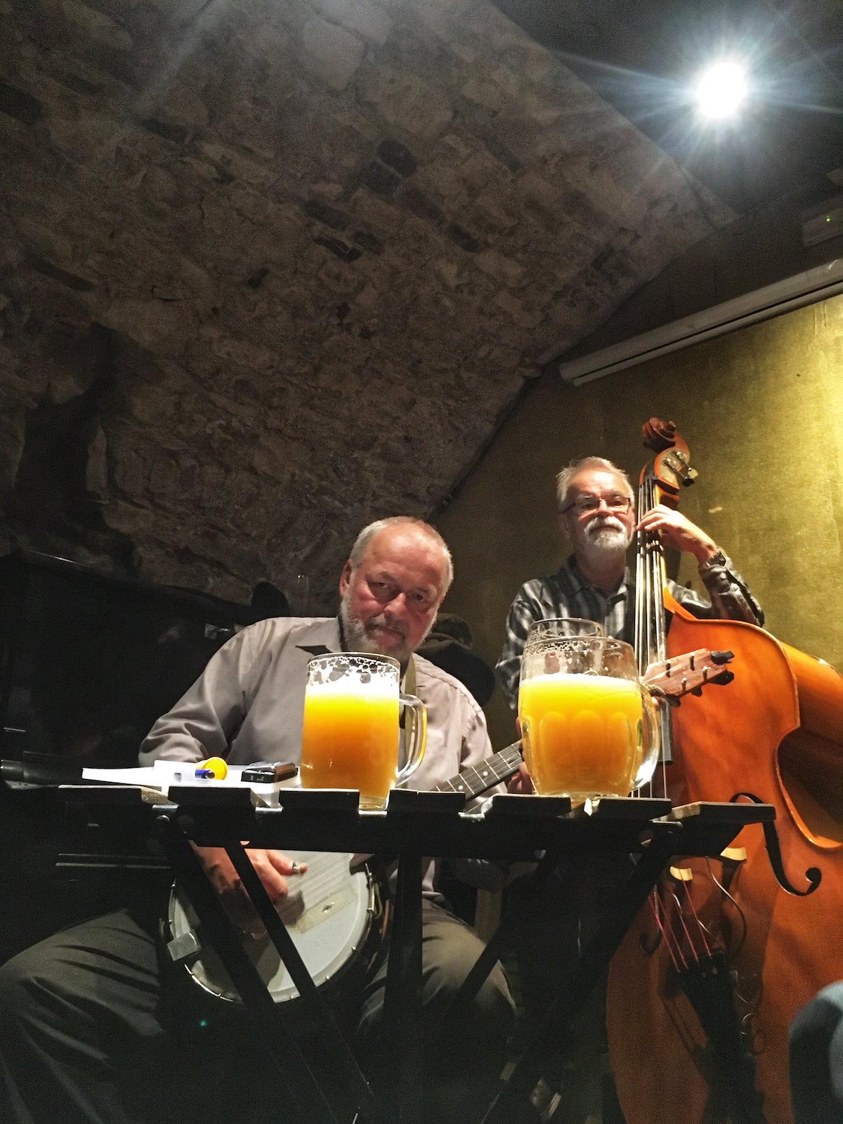 Banjo a kontrabas v Jazz baru na Praze 1, před nimi dvě vychlazená piva Permon